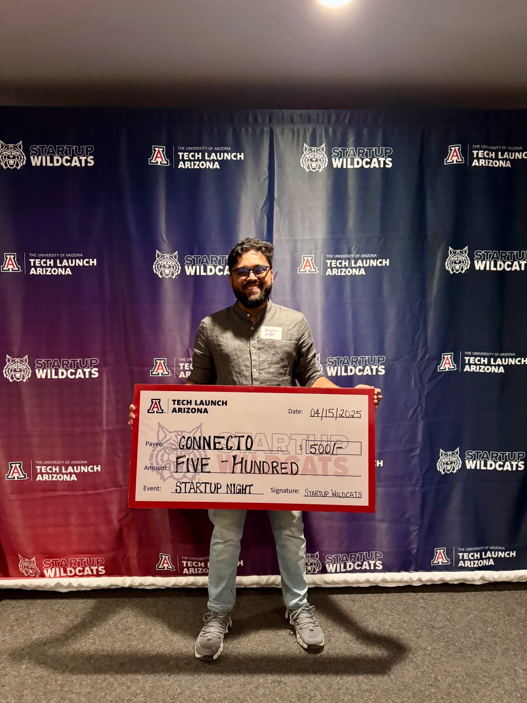 Arfan holding the $500 milestone funding check for Connecto